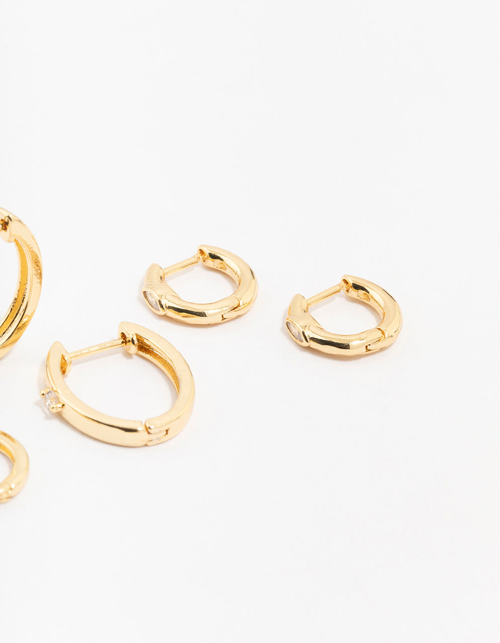 Showcasing gold plated brass graduating cubic zirconia earrings with hoop closure post detail view