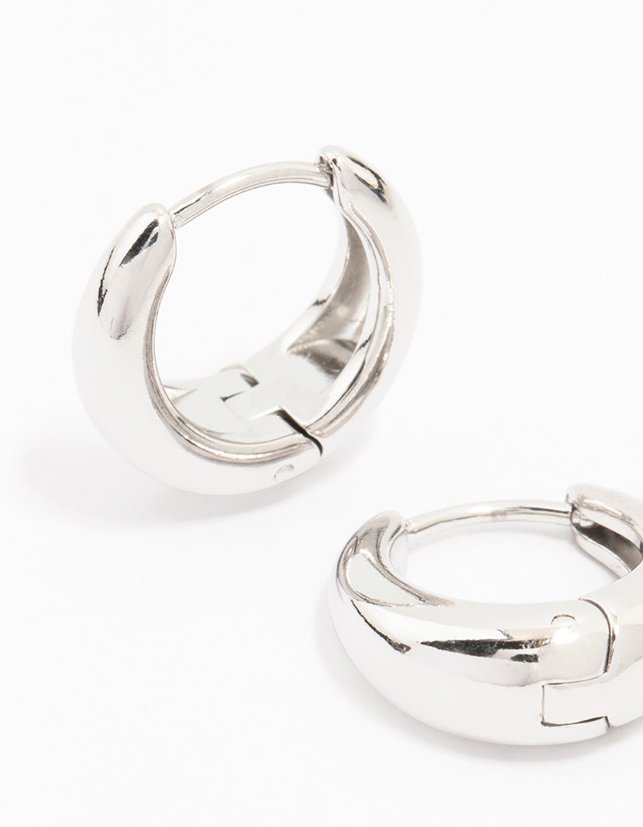 Designed with waterproof mini drop huggie earrings in stainless steel with hoop closure in silver close up view