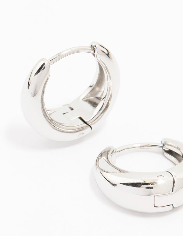 Designed with waterproof mini drop huggie earrings in stainless steel with hoop closure in silver close up view