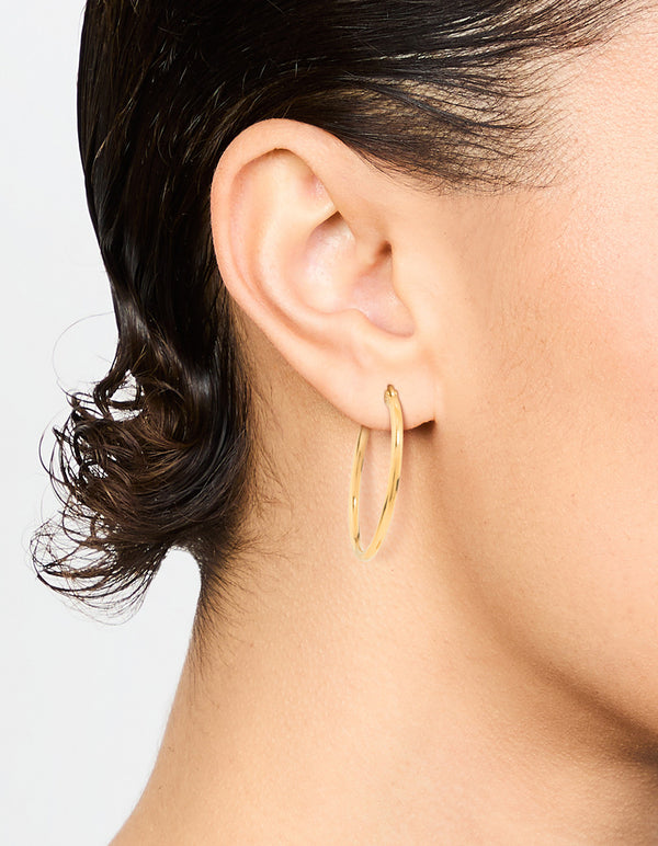 Showcasing waterproof fine hoop earrings crafted from gold plated stainless steel on ear view