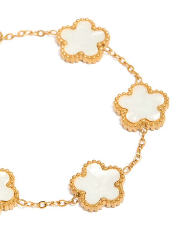 Featuring waterproof gold plated stainless steel construction, this flower petal charm bracelet highlights ivory floral detail close up view