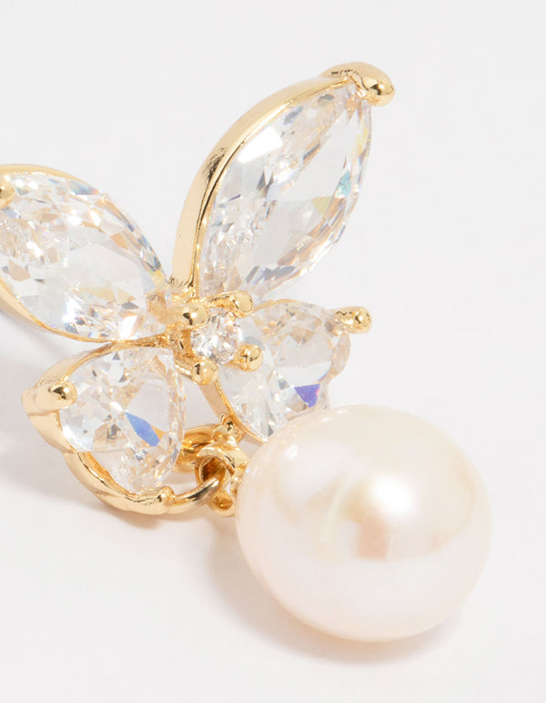 Detailed view of gold plated cubic zirconia butterfly pearl drop earrings with prong settings close up view