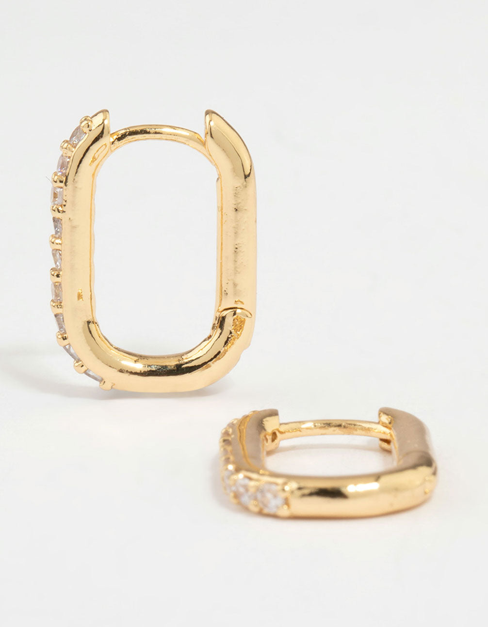 Crafted from gold plated metal, these diamante oval hoop earrings feature clear stones in a hoop closure front view