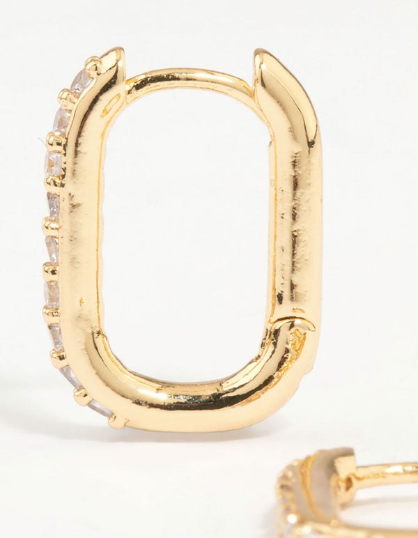 Detailed perspective of gold plated diamante oval hoop earrings highlighting stone settings and metal texture close up view