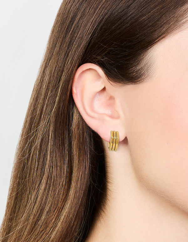 Showcasing waterproof gold plated stainless steel fluted hoop earrings in gold on ear view