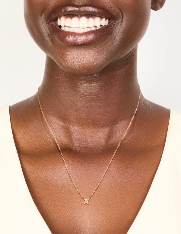 This gold plated sterling silver cubic zirconia pavé letter A necklace features initials and statement styling in gold and clear on neck view