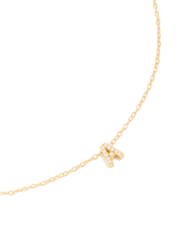 Showcasing a gold plated sterling silver cubic zirconia pavé letter A necklace with initials and statement design in gold and clear close up view