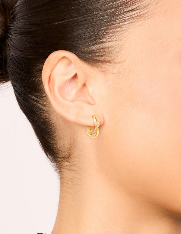 Featuring statement gold plated cubic zirconia twisted hoop earrings on ear view