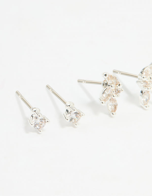 Displaying a flower stud and hoop earrings 4-pack with floral patterns crafted from cubic zirconia, crystal, and silver plated brass featuring stud, huggie closures in silver close up view