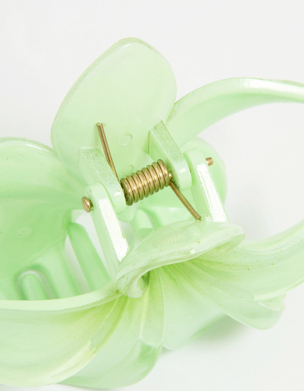Close-up of green ombre tropical claw clip showcasing floral design with gold metal clasp mechanism in pale and lime shades detail view