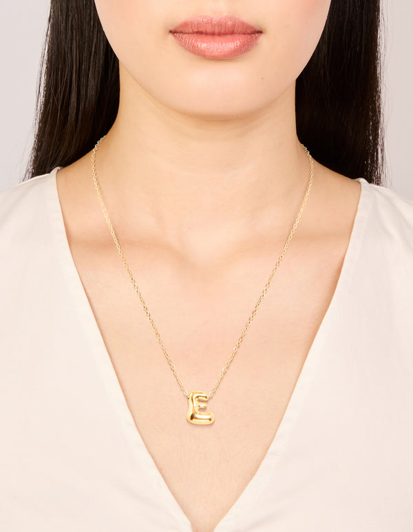 Featuring a waterproof large bubble letter E pendant necklace in stainless steel with a dainty design on neck view