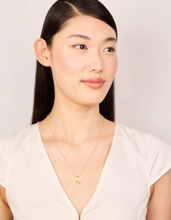 Designed with waterproof large bubble letter L dainty necklace in stainless steel featuring pendant with initials on model view