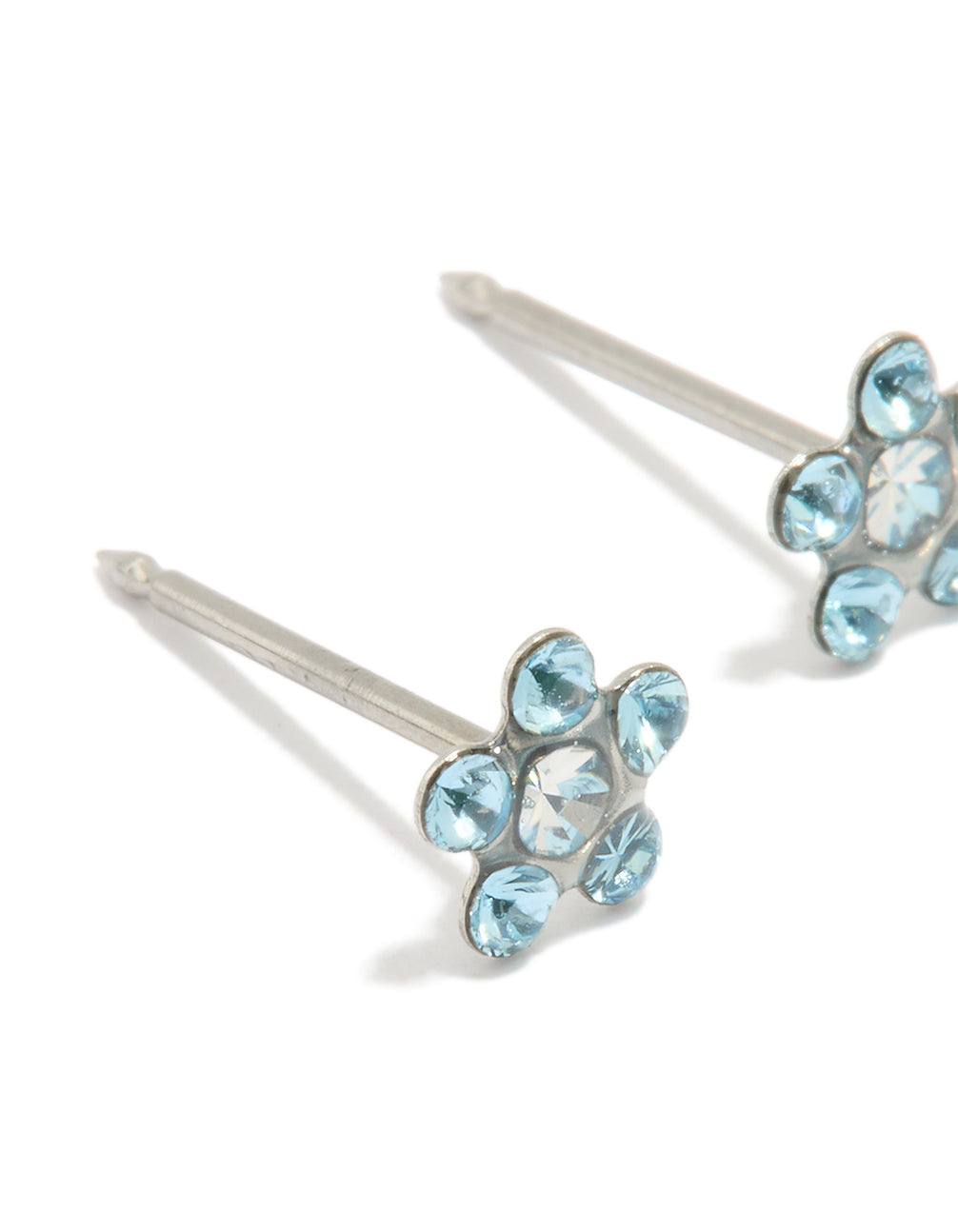 Crafted from surgical stainless steel with aqua cubic zirconia in a dainty floral daisy pattern close up view