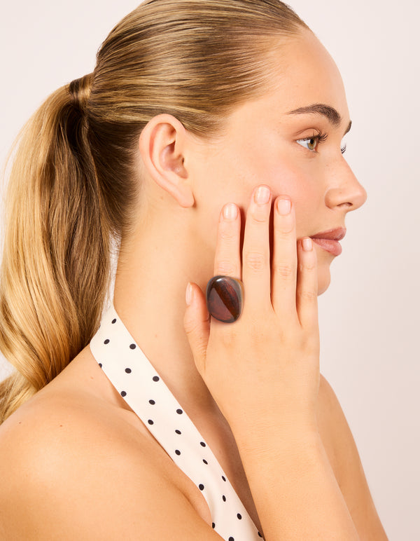 Featuring a dark brown acrylic large obtuse ring in chunky statement style on finger view