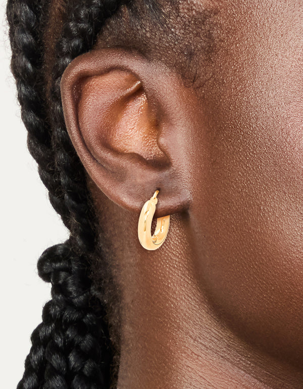 Featuring chunky waterproof hoop earrings in gold plated stainless steel on ear view