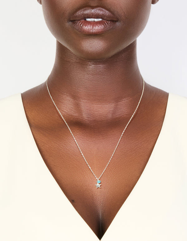 Showcasing a sterling silver blue cubic zirconia and starfish pendant necklace with ocean charm details in delicate crystal design on neck view