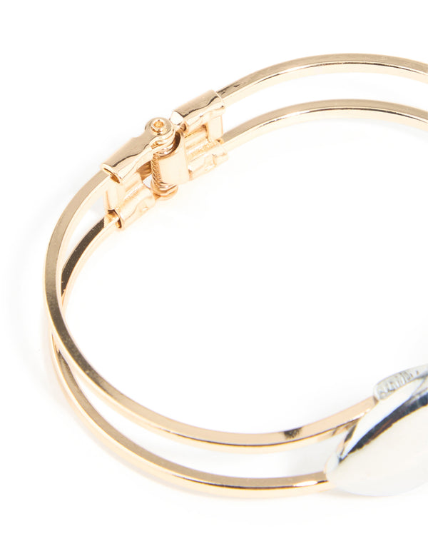 Highlighting the hinged closure of a heart bangle in mixed metals closure detail view