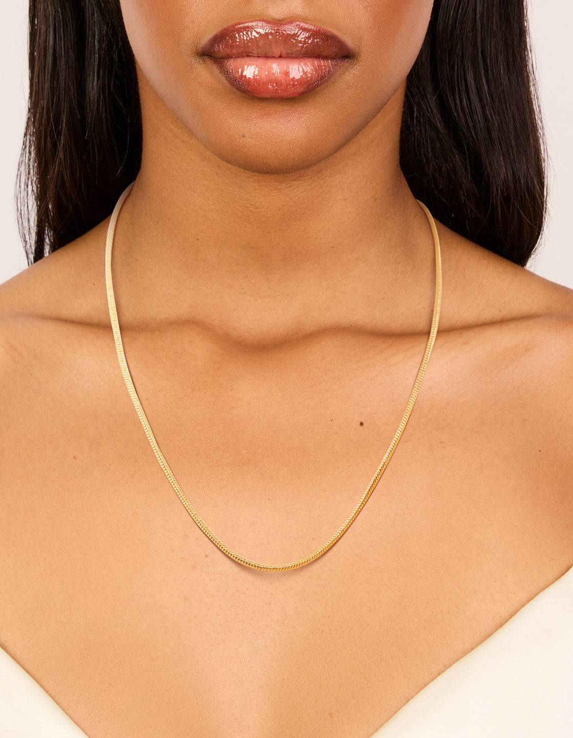 Displaying a waterproof snake short necklace crafted from stainless steel with dainty style in gold plated finish on neck view