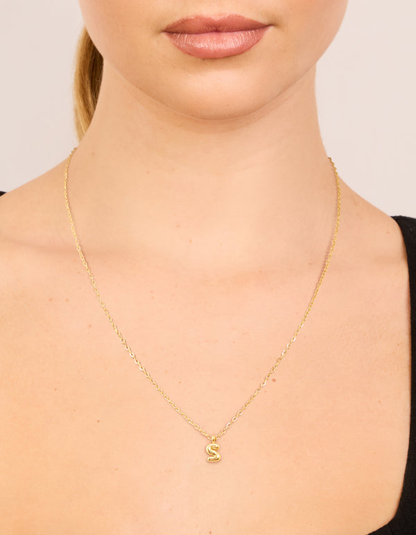 Featuring waterproof gold plated stainless steel with bubble letter S initial pendant necklace in dainty style on neck view