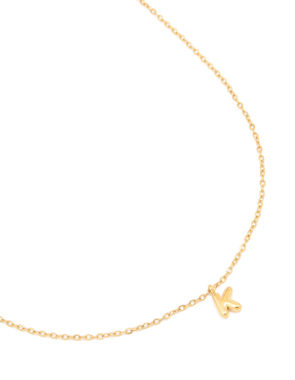 Showcasing a waterproof mini bubble letter K necklace crafted from gold plated stainless steel with initial pendant close up view