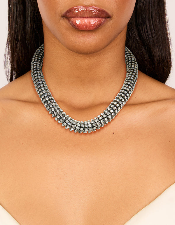 Showcasing a gunmetal diamante tube necklace in silver with statement styling on neck view