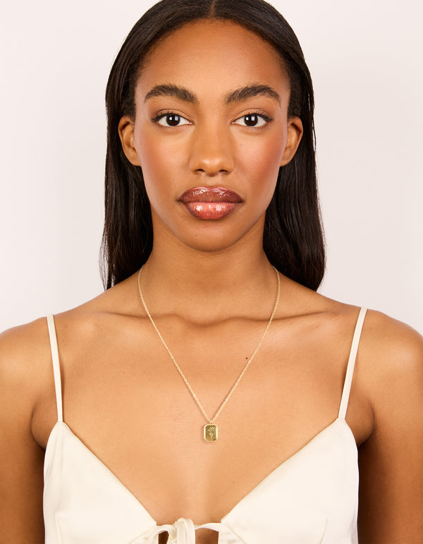Displaying a waterproof gold plated stainless steel floral detail dainty February birth flower violet necklace on model view