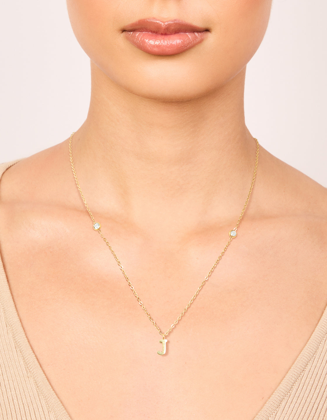 Showcasing a waterproof gold plated stainless steel letter J initial dainty pendant necklace on neck view