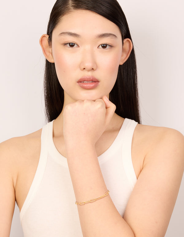 Designed with waterproof gold plated stainless steel fine link dainty clasp bracelet in gold on model view