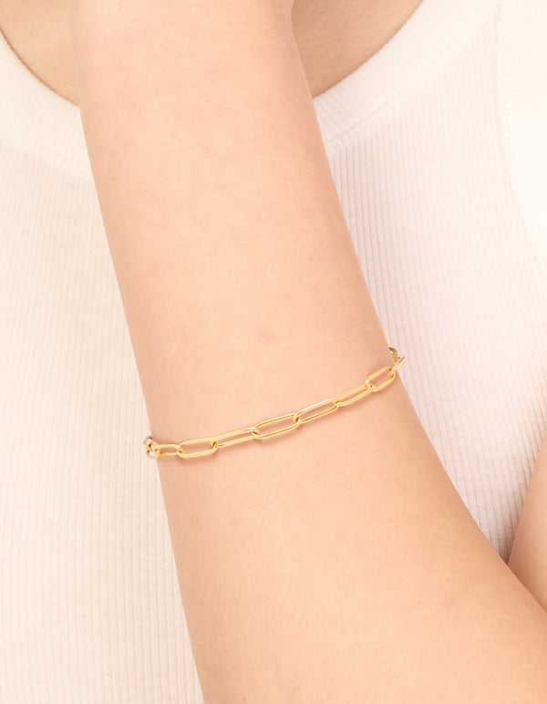 Showcasing a waterproof gold plated stainless steel fine link dainty clasp bracelet in gold on wrist view