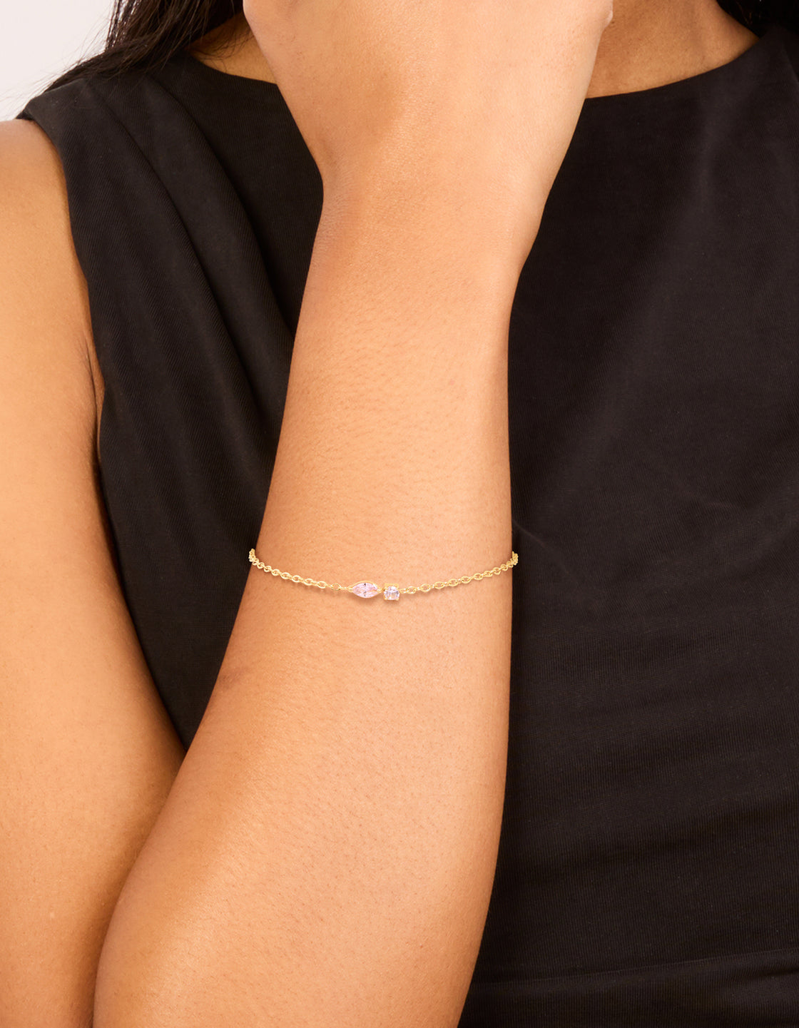 Featuring a waterproof bracelet in gold plated stainless steel with pink cubic zirconia detailing on wrist view