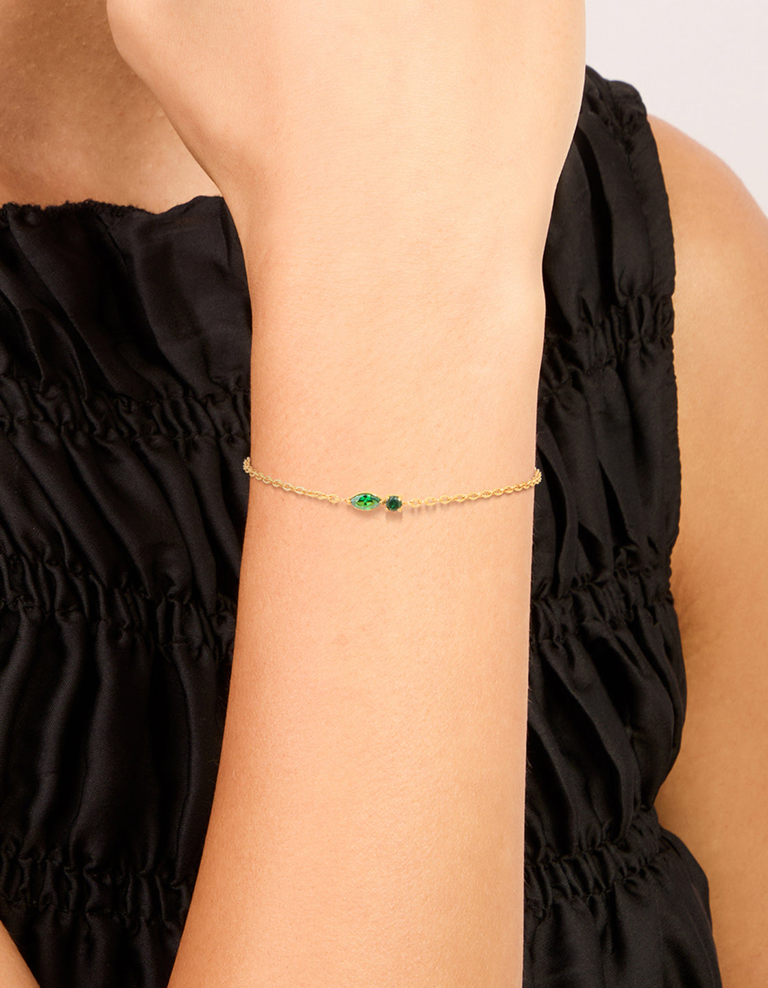 Featuring a waterproof gold plated stainless steel may green cubic zirconia birthstone bracelet in a dainty style on wrist view