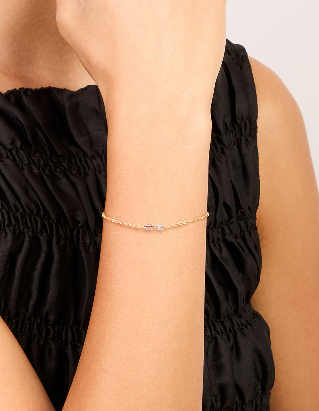 Showcasing a bracelet featuring waterproof stainless steel, February purple cubic zirconia birthstone details in a delicate chain on wrist view