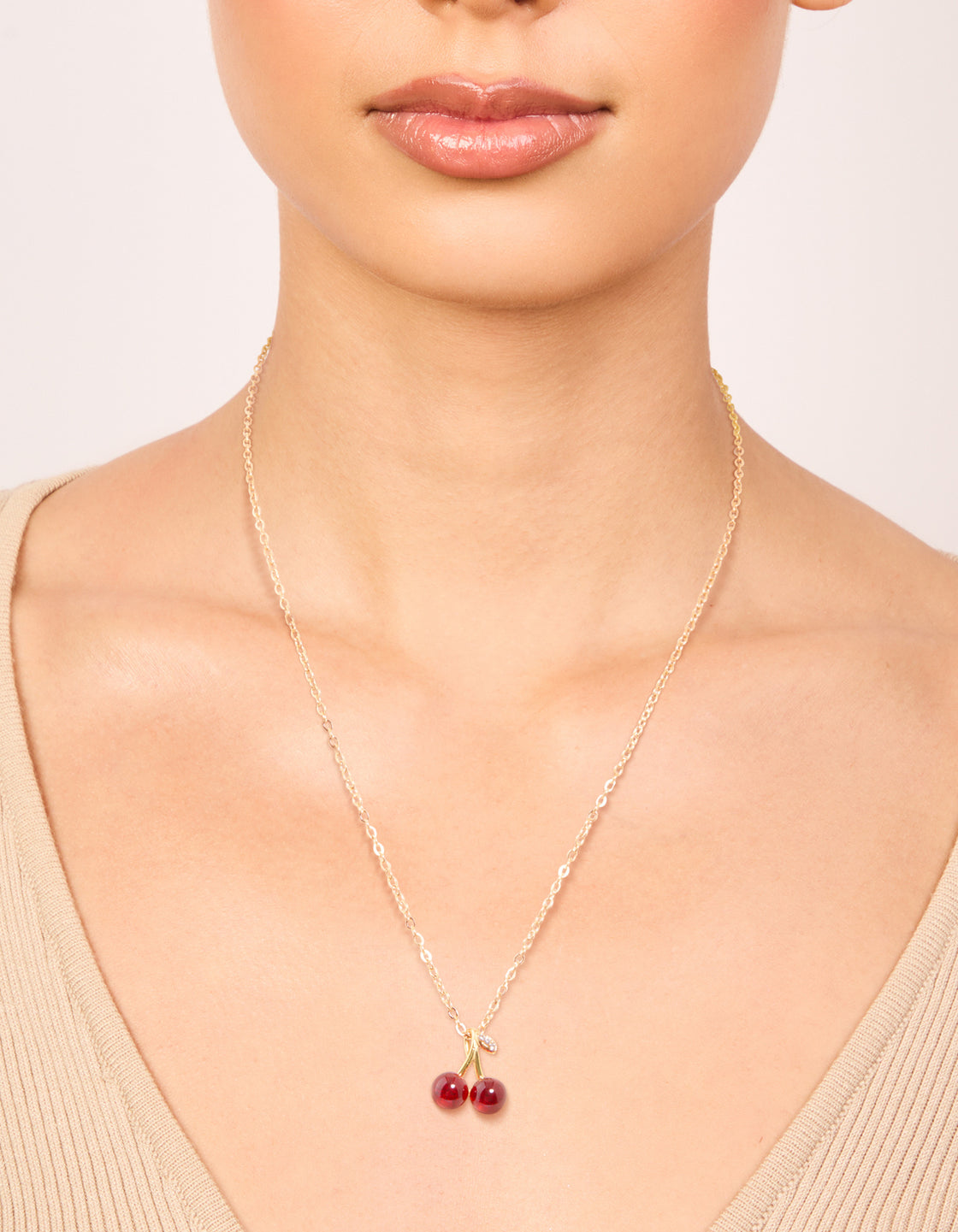 Featuring a waterproof red glass cherry pendant necklace crafted from gold plated stainless steel on neck view