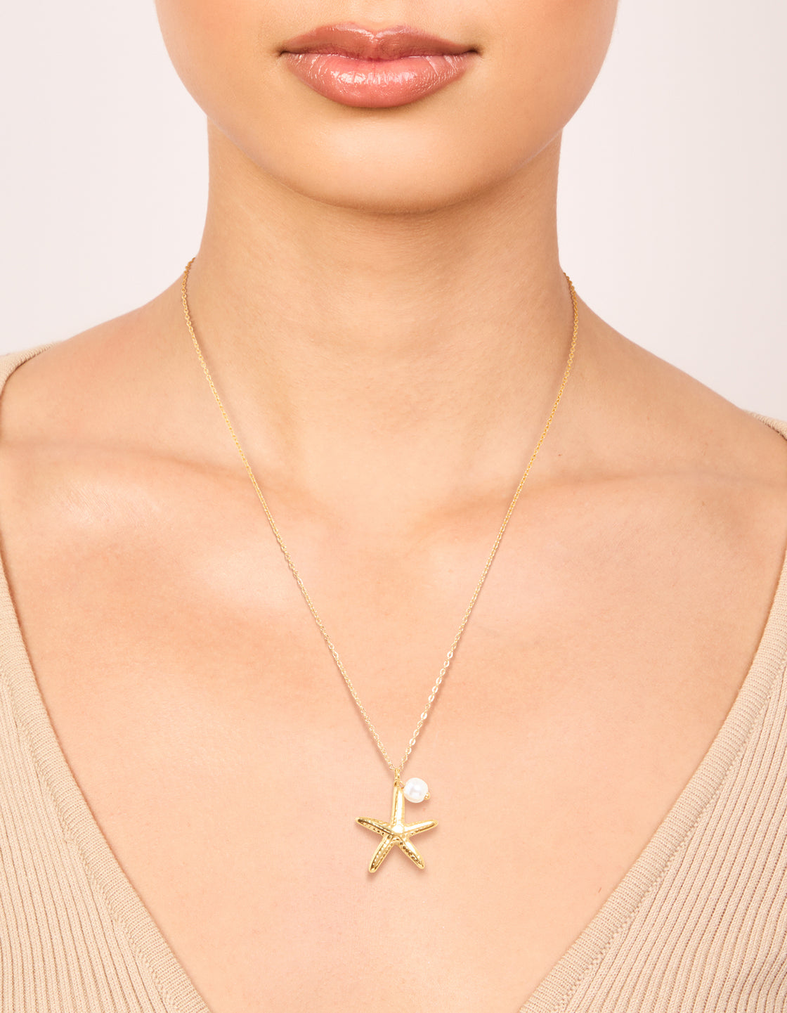 Featuring a waterproof gold plated starfish charm with pearl on stainless steel dainty pendant necklace on neck view