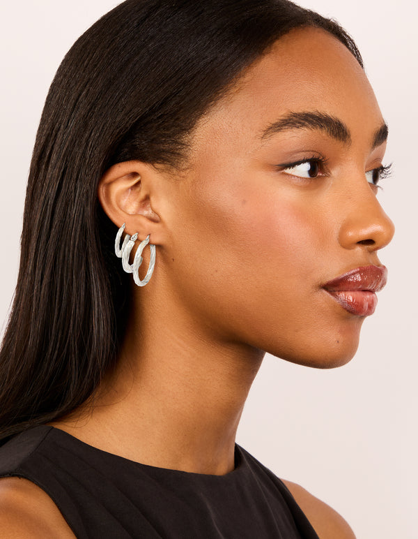 Displaying waterproof stainless steel twisted hoop earrings in a 3-pack with silver finish on model view