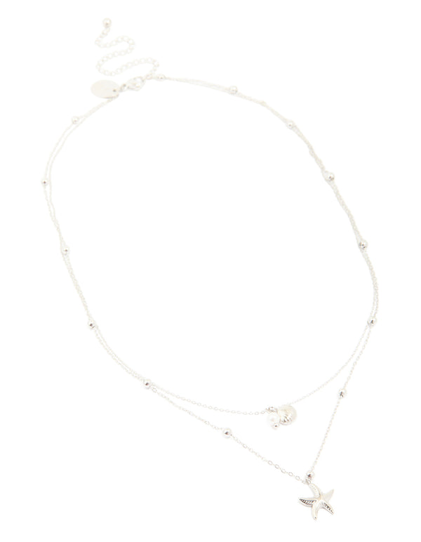 Featuring a waterproof stainless steel starfish and shell layered necklace with balls, charm, and pearl in silver showcasing ocean elements front view