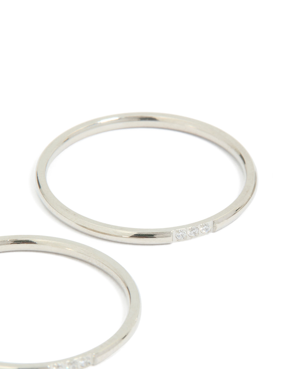 Showcasing waterproof stainless steel thin cubic zirconia trio rings in a 3-pack with silver and clear stone accents close up view
