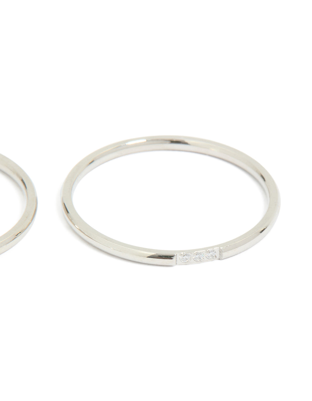 Showcasing waterproof stainless steel thin cubic zirconia trio rings in a 3-pack with silver and clear stone accents close up view