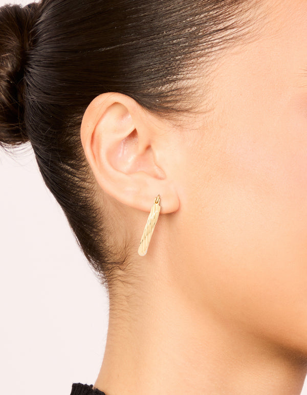 Showcasing waterproof gold plated stainless steel twisted medium hoop earrings on ear view