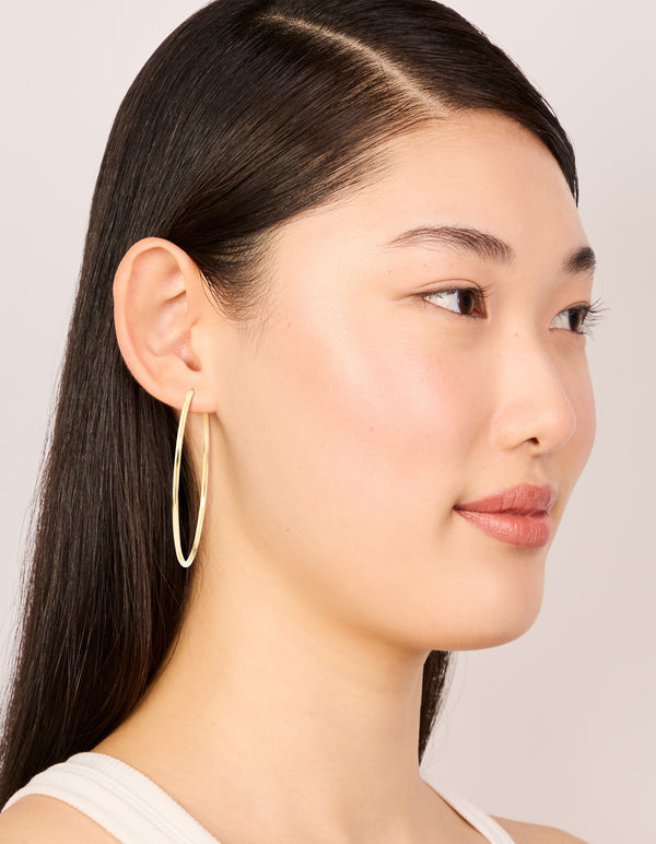 Featuring waterproof gold plated stainless steel hoop earrings in 55 MM size on model view