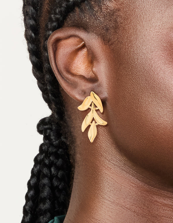 Featuring waterproof gold plated stainless steel cascading leaf drop stud earrings in botanical design on ear view