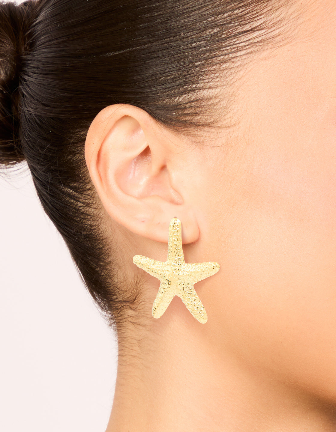 Waterproof gold plated stainless steel statement starfish stud earrings with ocean details on ear view