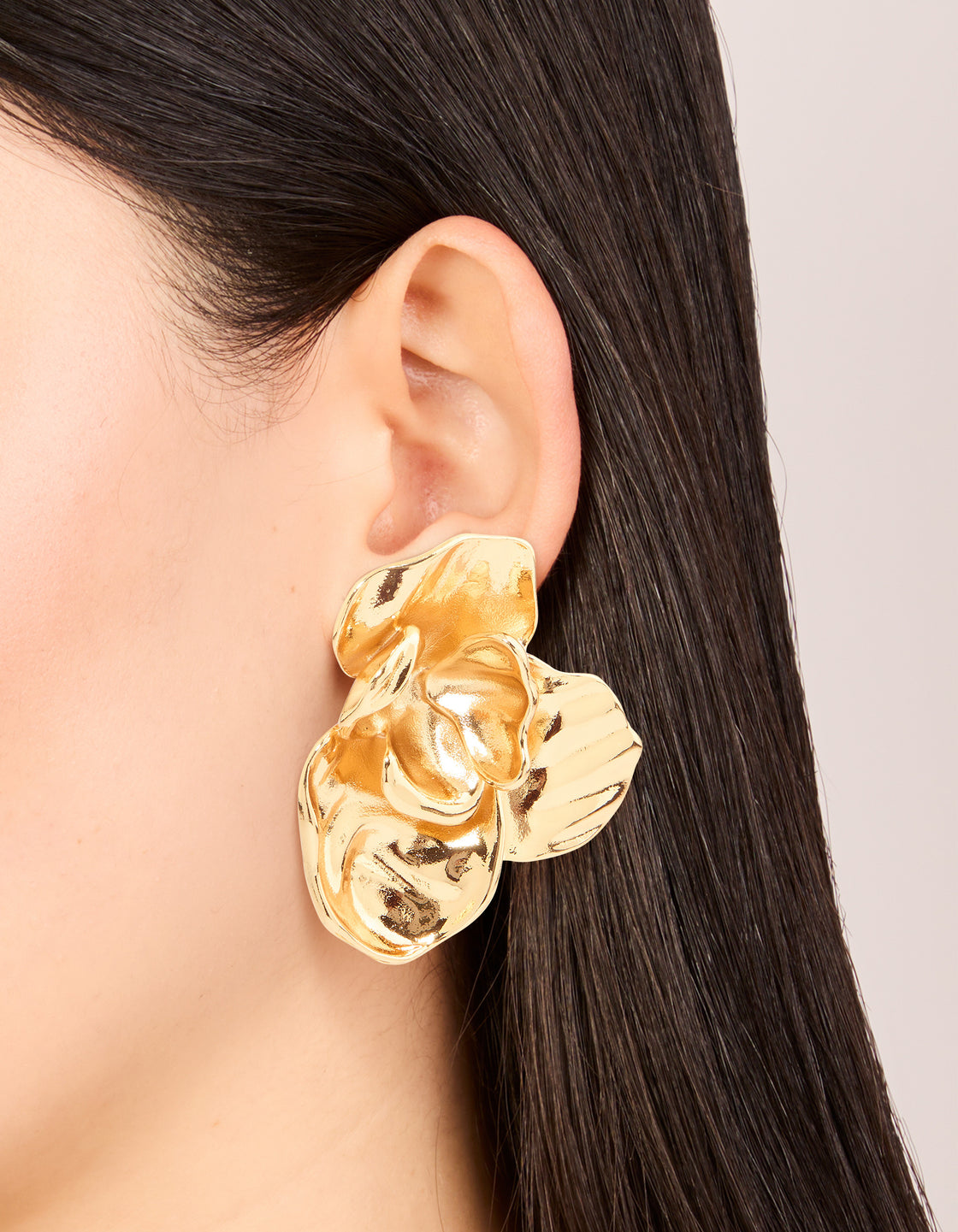 These waterproof gold plated stainless steel twisted textured stud earrings on ear view