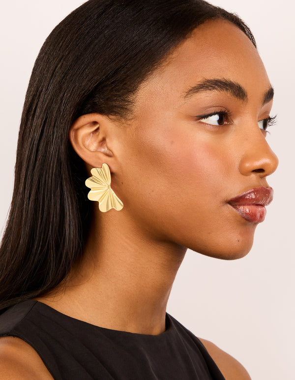 Crafted from waterproof gold plated stainless steel wavy fan flower stud earrings in gold on model view