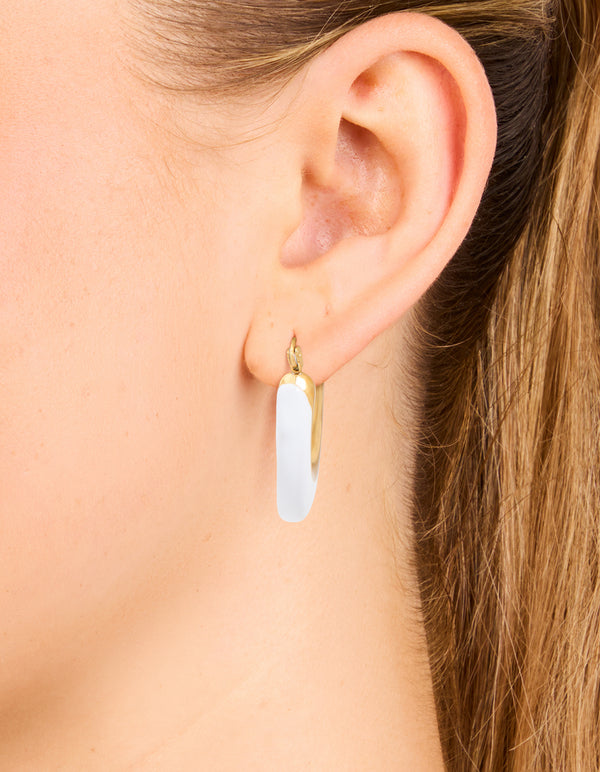 Featuring waterproof gold plated stainless steel hoop earrings with white enamel in long style on ear view