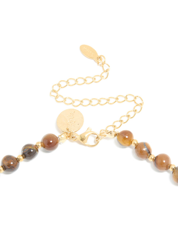 Highlighting a waterproof beaded tigers eye semi precious stone short necklace with gold plated stainless steel clasp detail view