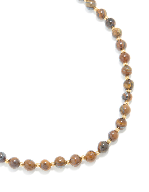 Showcasing a waterproof beaded tigers eye semi precious stone short necklace crafted from gold plated stainless steel close up view