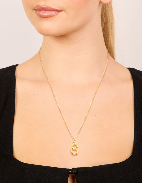 Featuring a waterproof initial necklace with bamboo letter S in gold plated stainless steel on neck view
