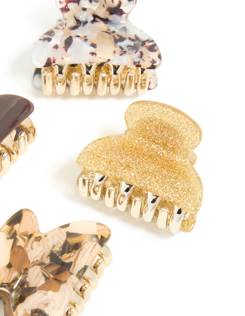 Featuring brown and gold acrylic claw clips in a 4-pack with glitter accessories detail view