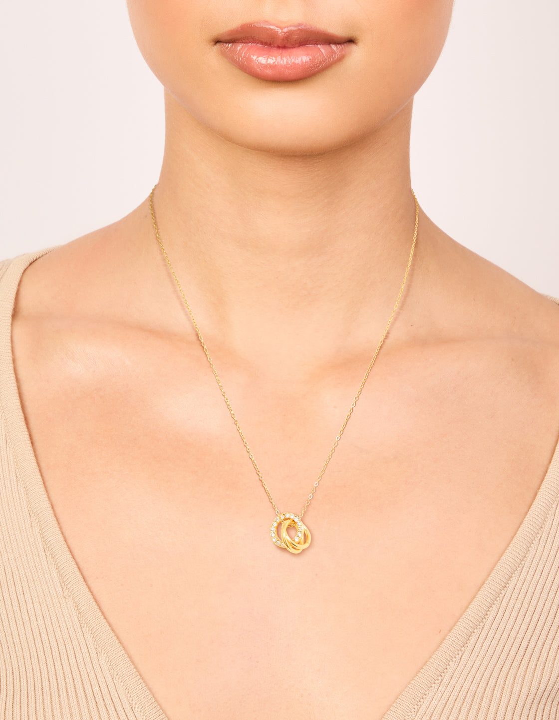 Showcasing a waterproof triple circle link necklace crafted from stainless steel with cubic zirconia in gold plated finish on neck view